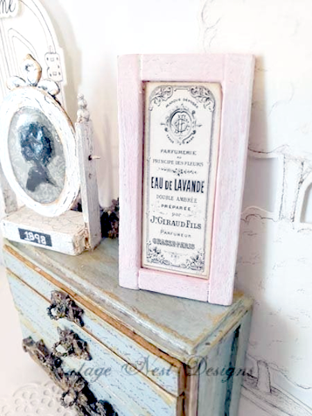 Decorative vintage sign on a distressed wooden surface with a white wall background.