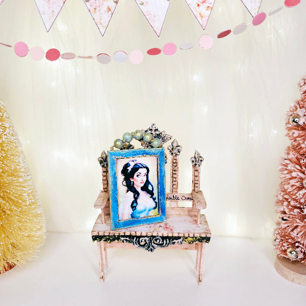Decorative setup with a chair, framed picture, and festive decorations on a white background
