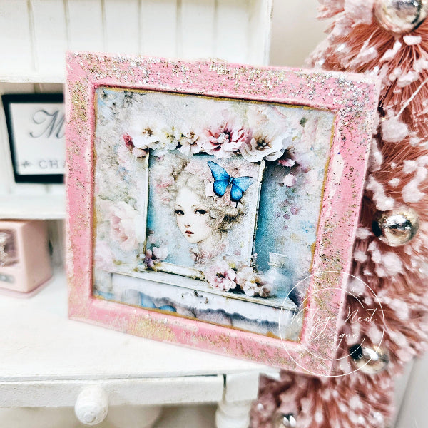 Decorative photo frame with floral design and butterfly on a white surface.